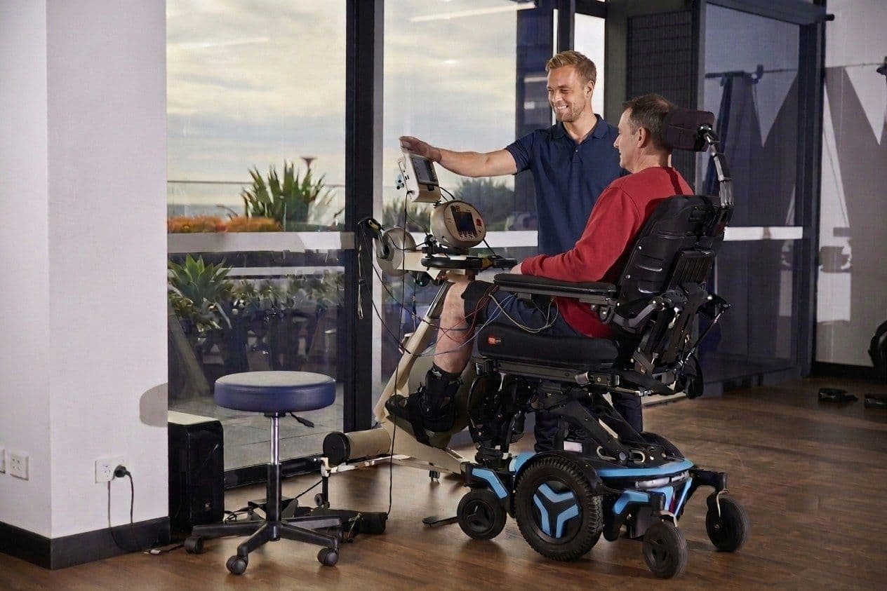 Fysiotherapeut begeleidt een cliënt tijdens een trainingssessie met de MOTOmed Viva 2